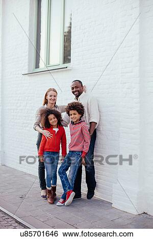 Portrait of parents and two children on sidewalk View Large Photo Image Stock Photograph - Portrait of parents and two children on sidewalk. Fotosearch