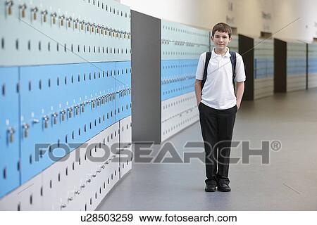 Stock Photo - Portrait of schoolboy with hands in pockets in school corridor. Fotosearch