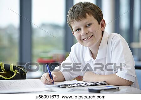 Stock Photo - Portrait of schoolboy writing in class. Fotosearch