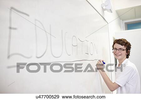 Stock Photo - Portrait of schoolboy writing on white board. Fotosearch