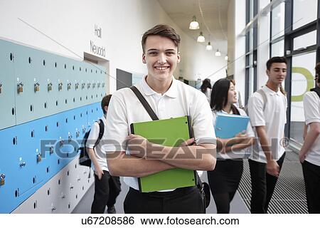 Portrait of teenage boy holding file in school corridor View Large Photo Image Stock Photograph - Portrait of teenage boy holding file in school corridor. Fotosearch
