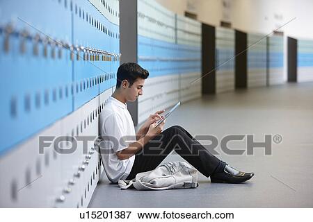 Portrait of teenage schoolboy sitting on floor next to lockers View Large Photo Image Stock Photo - Portrait of teenage schoolboy sitting on floor next to lockers. Fotosearch