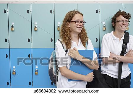 Stock Image - Portrait of teenagers next to school lockers. Fotosearch