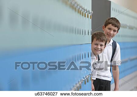 Stock Photo - Portrait of two schoolboys behind lockers. Fotosearch