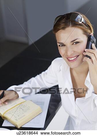 Picture - Portrait of young businesswoman using mobile phone. Fotosearch