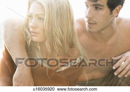 Stock Image - Portrait of young couple looking away, close up. Fotosearch