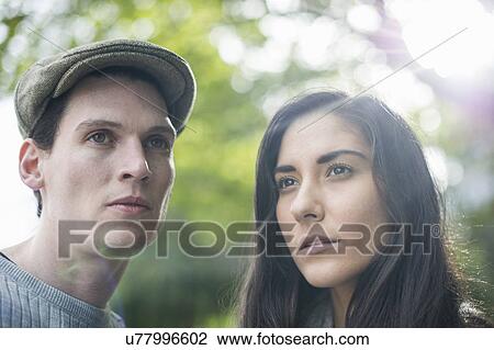 Stock Image - Portrait of young couple, man wearing flat cap. Fotosearch