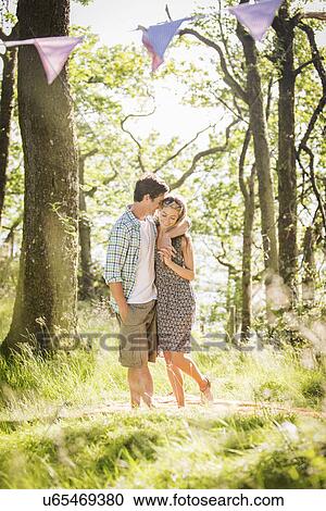 Portrait of young couple standing in forest View Large Photo Image Stock Image - Portrait of young couple standing in forest. Fotosearch