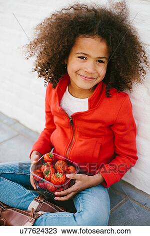 Portrait of young girl sitting cross legged with strawberries View Large Photo Image Stock Image - Portrait of young girl sitting cross legged with strawberries. Fotosearch