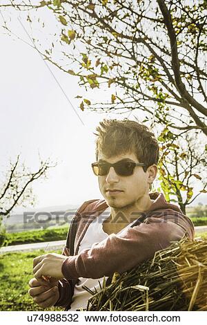 Portrait of young man leaning against haystack View Large Photo Image Stock Image - Portrait of young man leaning against haystack. Fotosearch