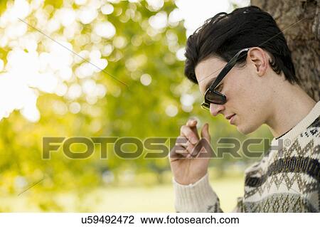 Portrait of young man wearing sunglasses View Large Photo Image Stock Image - Portrait of young man wearing sunglasses. Fotosearch