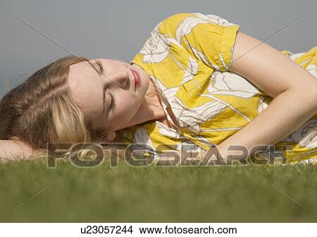 Portrait of young woman daydreaming on grass View Large Photo Image Picture - Portrait of young woman daydreaming on grass. Fotosearch