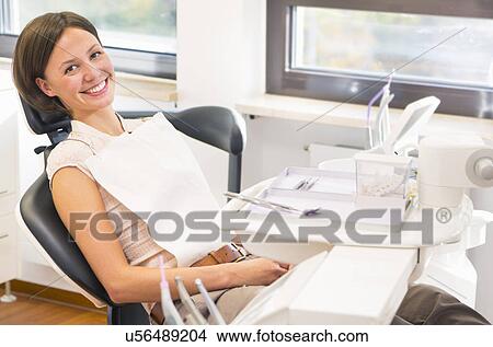 Picture - Portrait of young woman in dentists chair, smiling. Fotosearch
