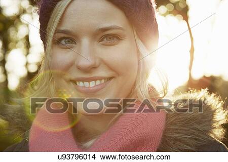 Portrait of young woman in park, wearing knit hat and scarf View Large Photo Image Picture - Portrait of young woman in park, wearing knit hat and scarf. Fotosearch