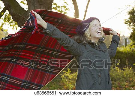 Portrait of young woman in park, holding up tartan picnic blanket View Large Photo Image Stock Image - Portrait of young woman in park, holding up tartan picnic blanket. Fotosearch