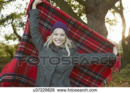 Portrait of young woman in park, holding up tartan picnic blanket View Large Photo Image Stock Photo - Portrait of young woman in park, holding up tartan picnic blanket. Fotosearch