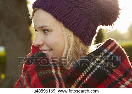 Portrait of young woman in park, tartan picnic blanket around shoulders View Large Photo Image Stock Photo - Portrait of young woman in park, tartan picnic blanket around shoulders. Fotosearch