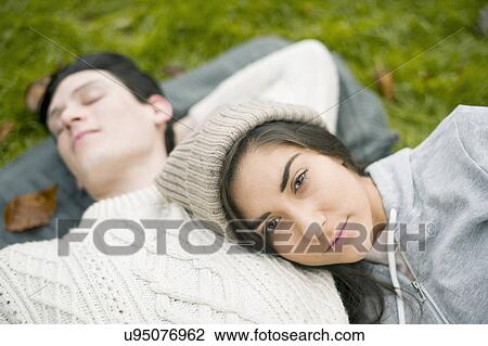 Stock Image - Portrait of young woman resting head on man's chest. Fotosearch