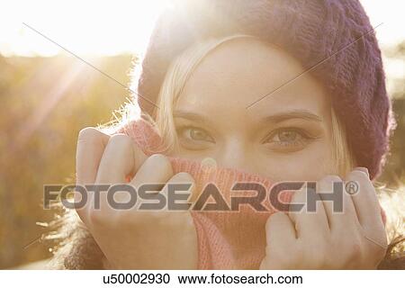 Portrait of young woman wearing knit hat, mouth covered View Large Photo Image Stock Image - Portrait of young woman wearing knit hat, mouth covered. Fotosearch
