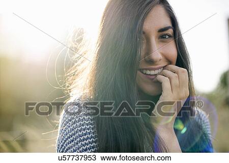 Portrait of young woman with long brown hair, smiling View Large Photo Image Stock Image - Portrait of young woman with long brown hair, smiling. Fotosearch