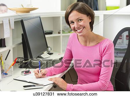 Receptionist writing at desk View Large Photo Image Stock Image - Receptionist writing at desk. Fotosearch