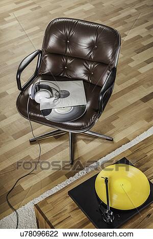 Stock Image - Retro brown leather armchair and vinyl records. Fotosearch