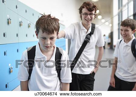Schoolboy being bullied in school corridor View Large Photo Image Picture - Schoolboy being bullied in school corridor. Fotosearch