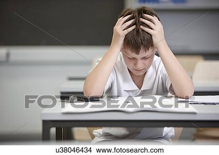 Picture - Schoolboy struggling in educational exam. Fotosearch