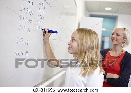 Schoolgirl doing multiplication on white board View Large Photo Image Stock Photography - Schoolgirl doing multiplication on white board. Fotosearch
