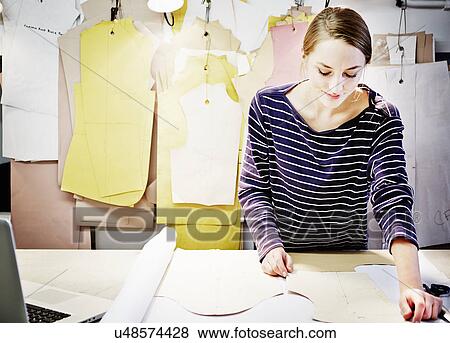 Stock Photo - Seamstress working at table. Fotosearch
