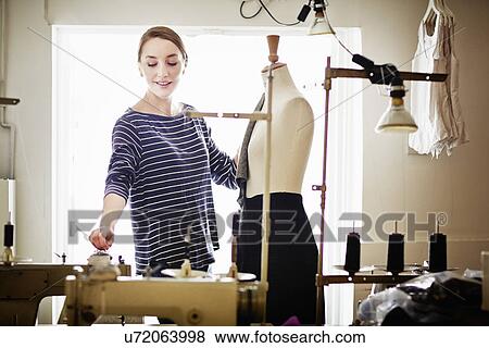 Seamstress working at tailors dummy View Large Photo Image Stock Photo - Seamstress working at tailors dummy. Fotosearch