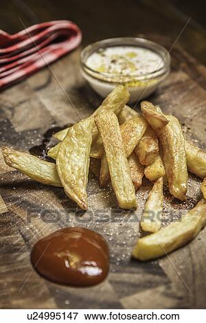 Stock Photo - Still life of potato fries, ketchup and dip. Fotosearch