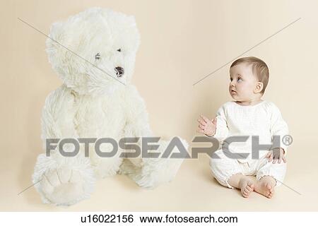 Studio portrait of baby girl next to giant teddy bear View Large Photo Image Stock Photograph - Studio portrait of baby girl next to giant teddy bear. Fotosearch