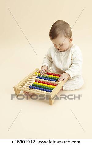 Studio portrait of baby girl playing with abacus View Large Photo Image Stock Image - Studio portrait of baby girl playing with abacus. Fotosearch