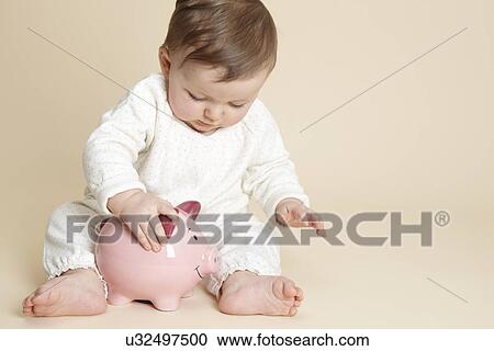 Studio portrait of baby girl playing with piggy bank View Large Photo Image Stock Image - Studio portrait of baby girl playing with piggy bank. Fotosearch