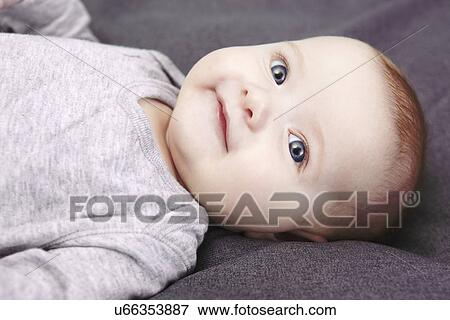 Studio portrait of smiling baby girl lying on back View Large Photo Image Stock Photo - Studio portrait of smiling baby girl lying on back. Fotosearch