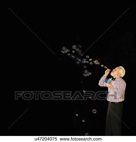 Studio shot of senior man blowing bubbles View Large Photo Image Stock Photography - Studio shot of senior man blowing bubbles. Fotosearch