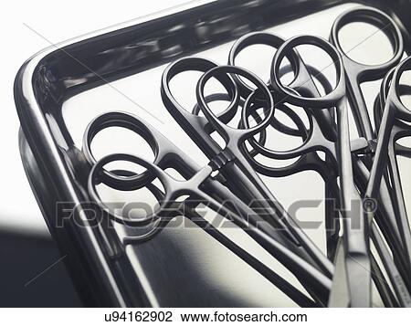 Stock Image - Surgical instruments on a stainless steel tray. Fotosearch