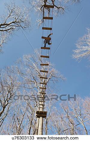 Teenage boy on rope bridge, low angle View Large Photo Image Stock Image - Teenage boy on rope bridge, low angle. Fotosearch