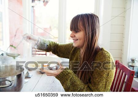 Teenage girl serving herself meal at kitchen table View Large Photo Image Stock Photo - Teenage girl serving herself meal at kitchen table. Fotosearch
