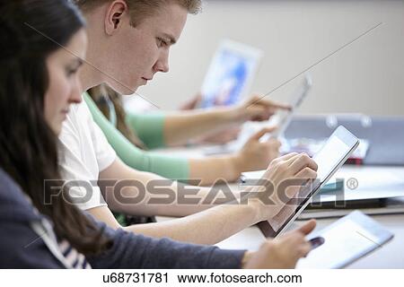 Teenagers using digital tablets classroom View Large Photo Image Stock Image - Teenagers using digital tablets classroom. Fotosearch