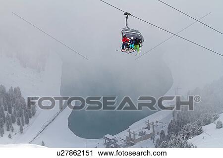Stock Image - Three people on ski lift in Kuhtai, Austria. Fotosearch