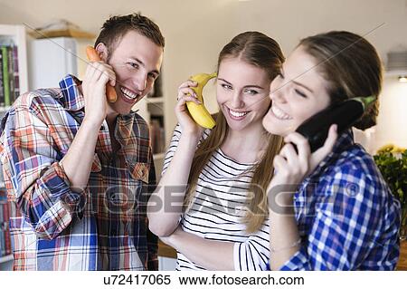 Three young people having fun using fruit as telephones View Large Photo Image Stock Photography - Three young people having fun using fruit as telephones. Fotosearch