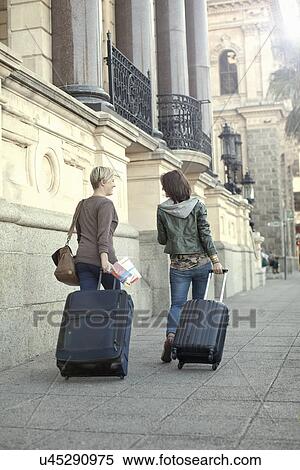 Two female friends pulling suitcases on sidewalk, Cape Town, South Africa View Large Photo Image Stock Photography - Two female friends pulling suitcases on sidewalk, Cape Town, South Africa. Fotosearch