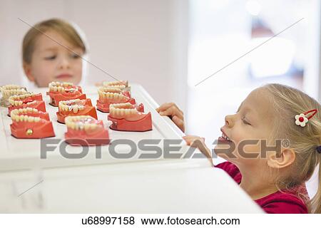 Two girls looking at false teeth View Large Photo Image Stock Photo - Two girls looking at false teeth. Fotosearch