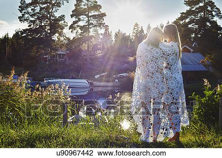 Two young adult female friends wrapped in blanket, Gavle, Sweden View Large Photo Image Stock Image - Two young adult female friends wrapped in blanket, Gavle, Sweden. Fotosearch