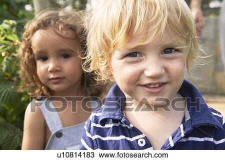 Two young boys playing in garden View Large Photo Image Stock Image - Two young boys playing in garden. Fotosearch
