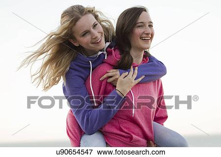 Stock Photo - Two young female friends having fun on beach, Whitstable, Kent, UK. Fotosearch