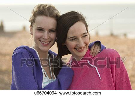 Picture - Two young female friends on beach at Whitstable, Kent, UK. Fotosearch