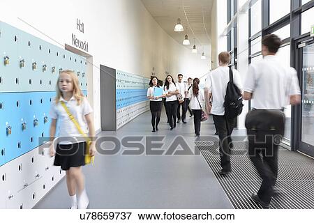 Unhappy schoolgirl walking in school corridor View Large Photo Image Stock Photo - Unhappy schoolgirl walking in school corridor. Fotosearch